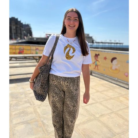 Llun merch yn gwisgo crys=T gyda tafod print llewpart